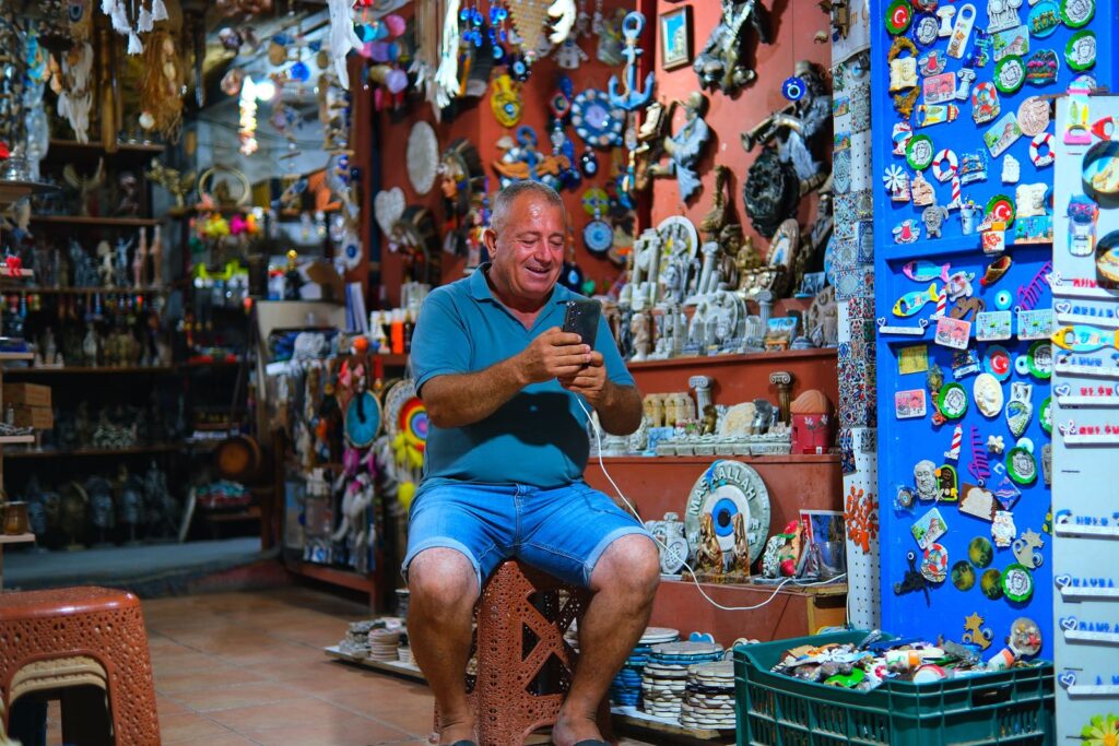 Shop owner using his smartphone inside his small shop